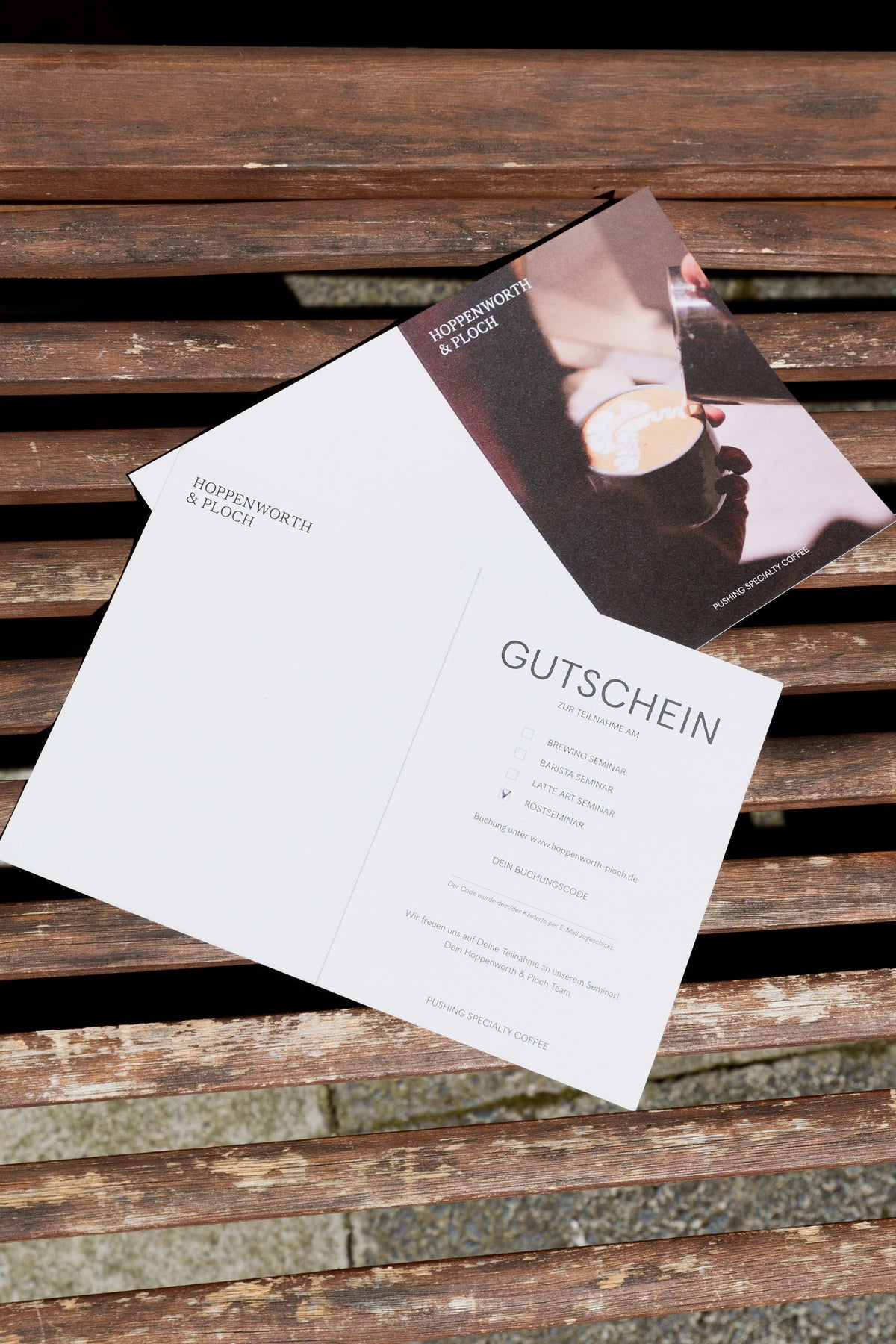 eine Gutscheinkarte, im Hintergrund liegt sie von der anderen Seite